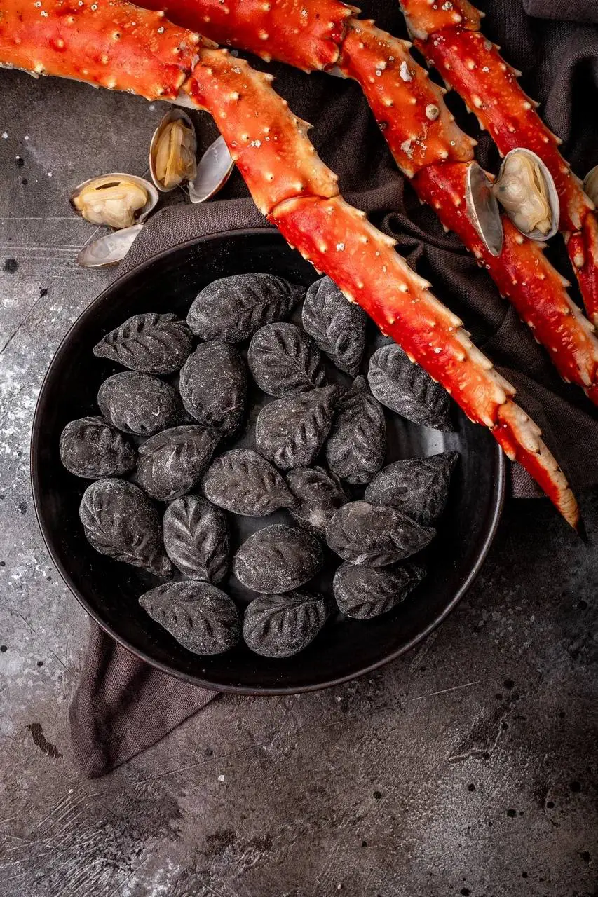 Черные пельмени с крабом, палтусом и сыром рикотта